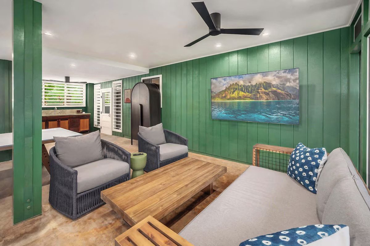 Lounge seating in the downstairs rec room with an arched doorway and smart TV.