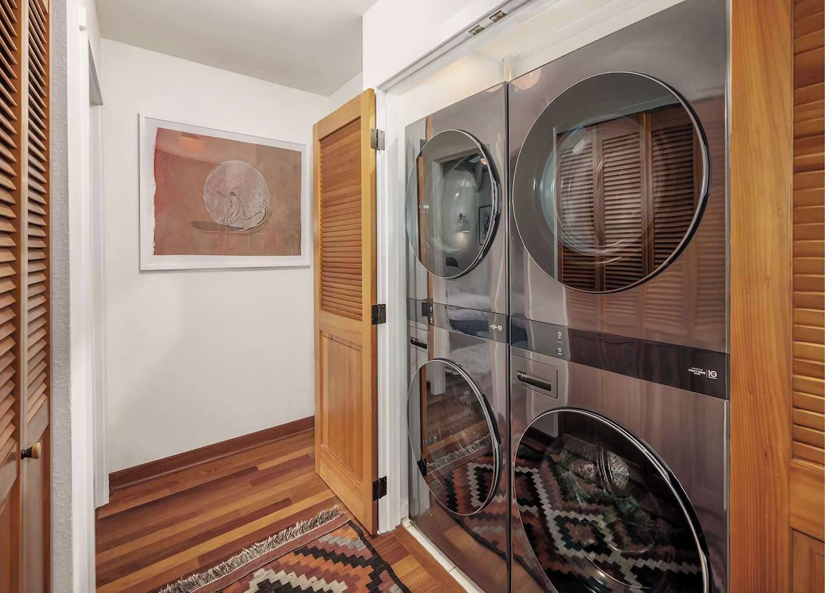 Stacked full-size washer and dryer in a louvered closet off the hall.